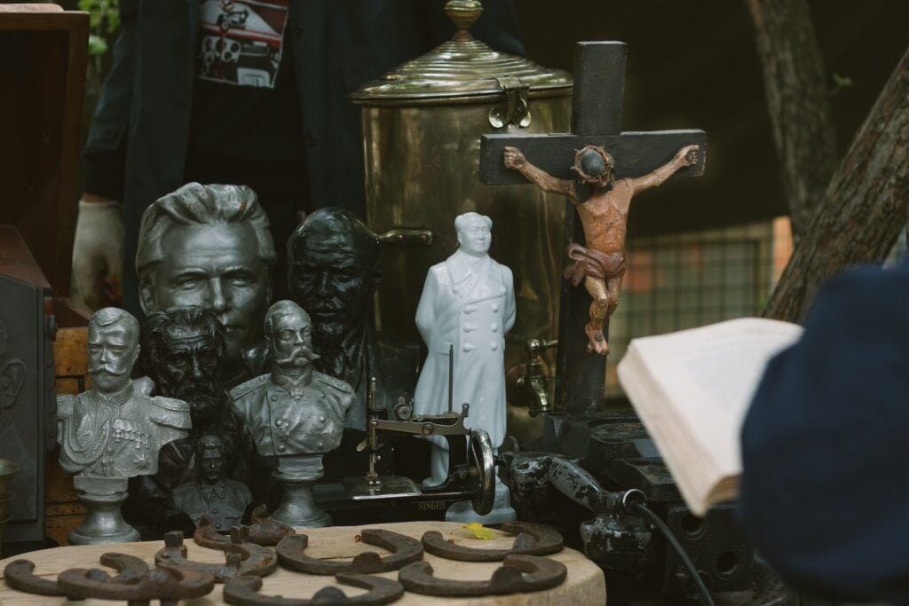 a crucifix, figurines and a book on a table
