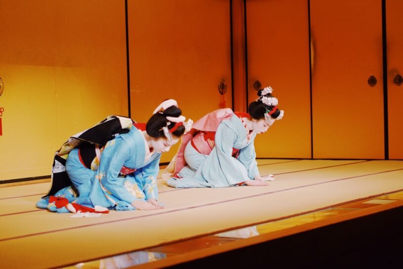 two Geisha on kneeling brown floor