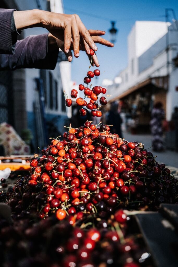 a pile of cherries being picked from a bin